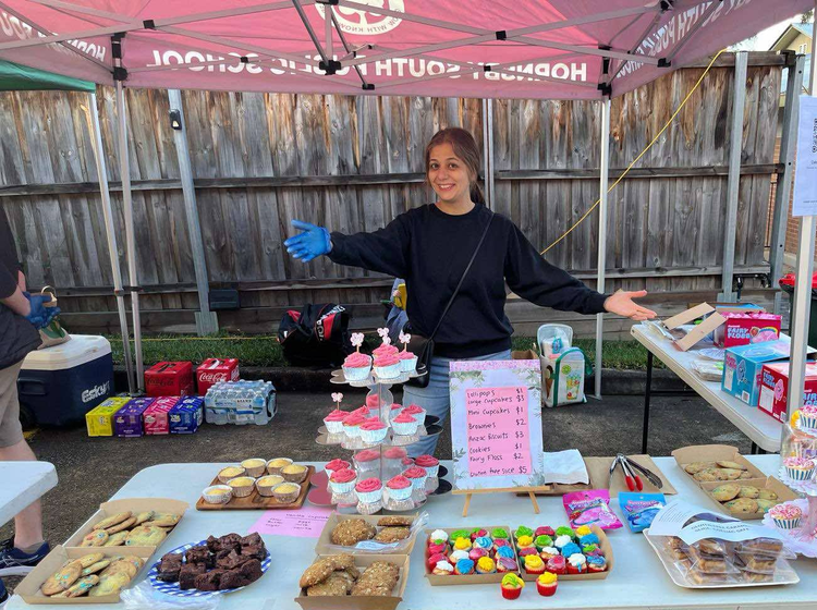 A parent volunteer helping at a P&C bake stall