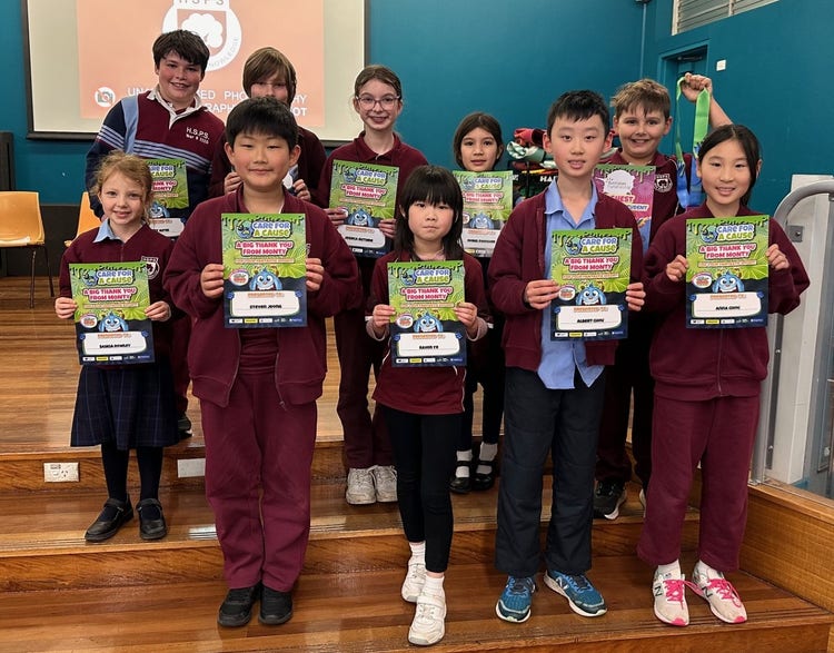 Children standing on stage with an award