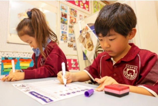 Two kindergarten students working at their desks