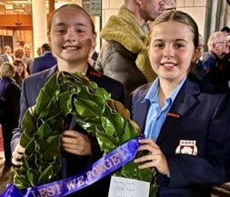 Two student leaders holding a wreath for an ANZAC ceremony