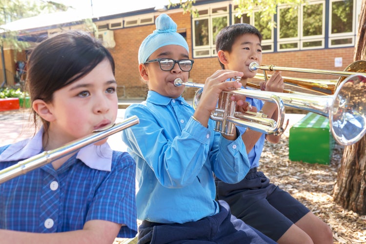 Three students playing an instrument