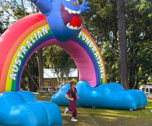 A student running through the fun run arch
